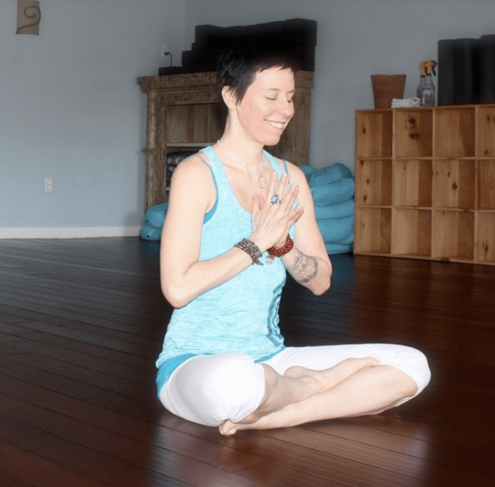 yogi sitting with hands to prayer