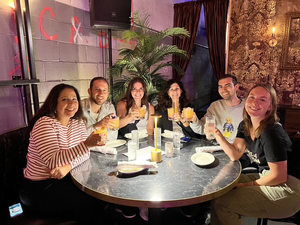 a group sitting at a table together with drinks